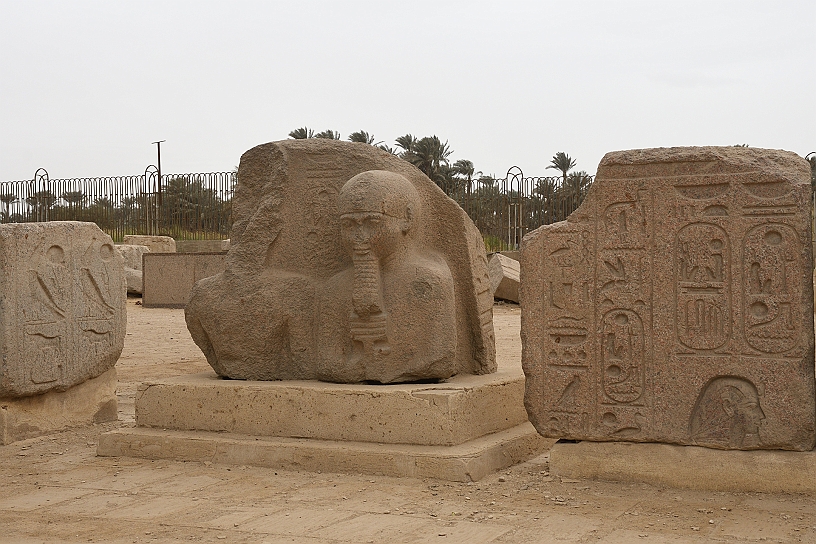 19 MAK_6867.jpg - La scultura centrale raffigura Ramesse II, molto danneggiato, con Ptah, la divinità principale di Menfi, dio della creazione rappresentato in forma mummiforme con il cranio liscio e una barba dritta, simboli della sua natura eterna e del suo potere sulla vita e sulla morte.